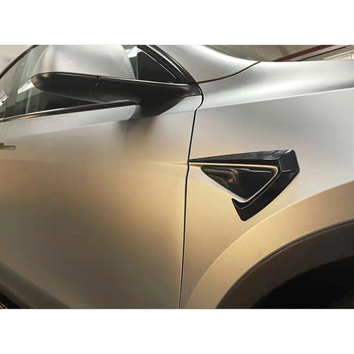 Glossy black Aero Style side camera decoration trim on white Tesla Model Y